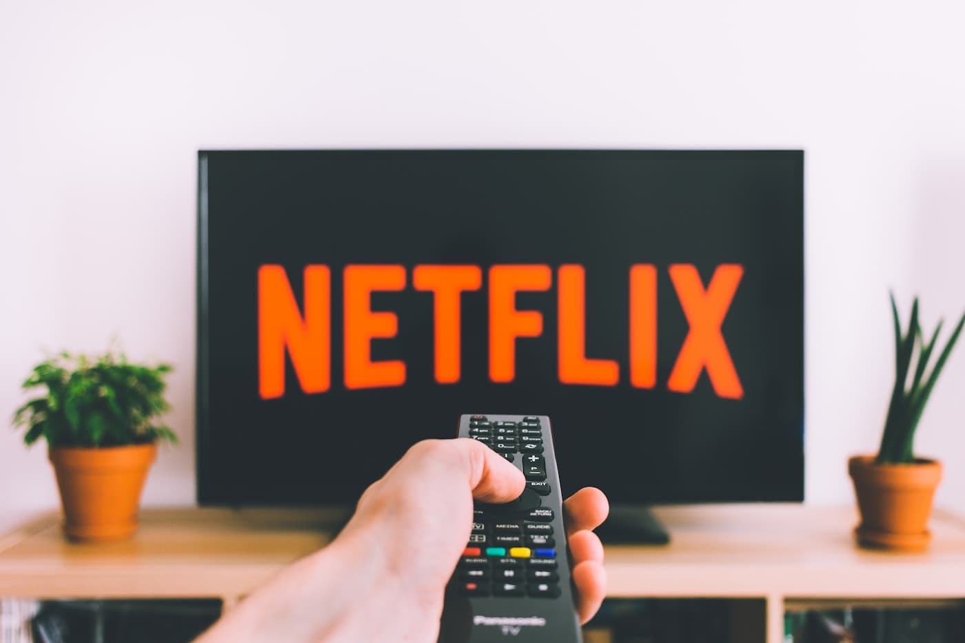Mando a distancia frente a televisor con logo de streaming — deseo de pantalla grande en casa